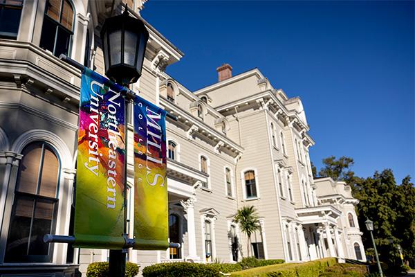 Front of Mills Hall with colorful banners on lamp post