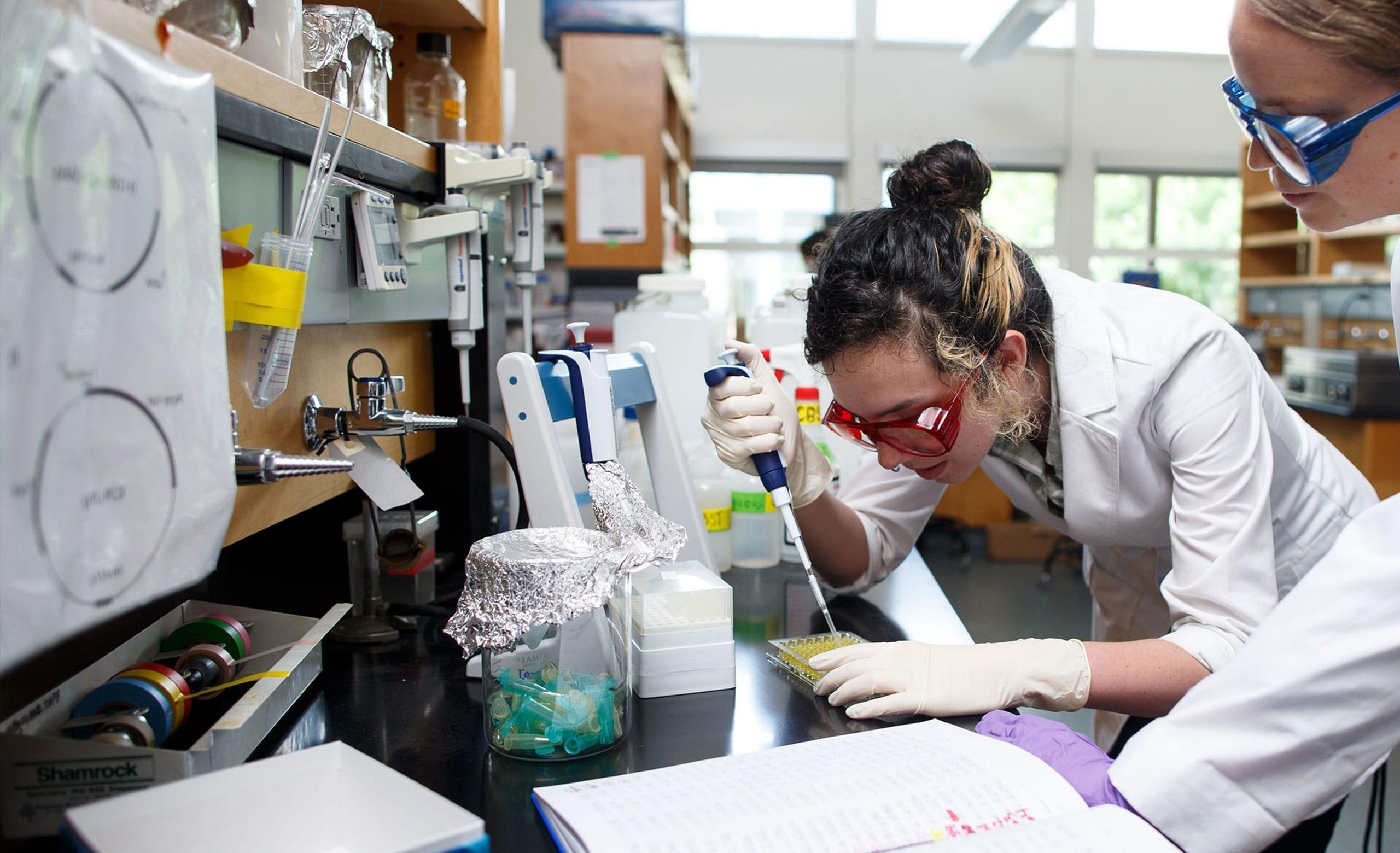 Students wearing safety glasses with lab equipment at Northeastern University's Oakland campus