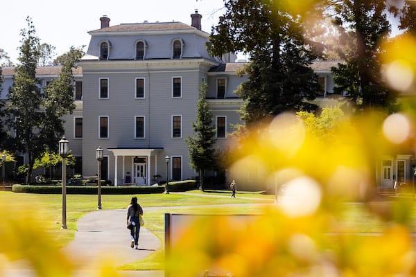 Students walking on path through Holmgren Meadow near Mills Hall on the Oakland campus